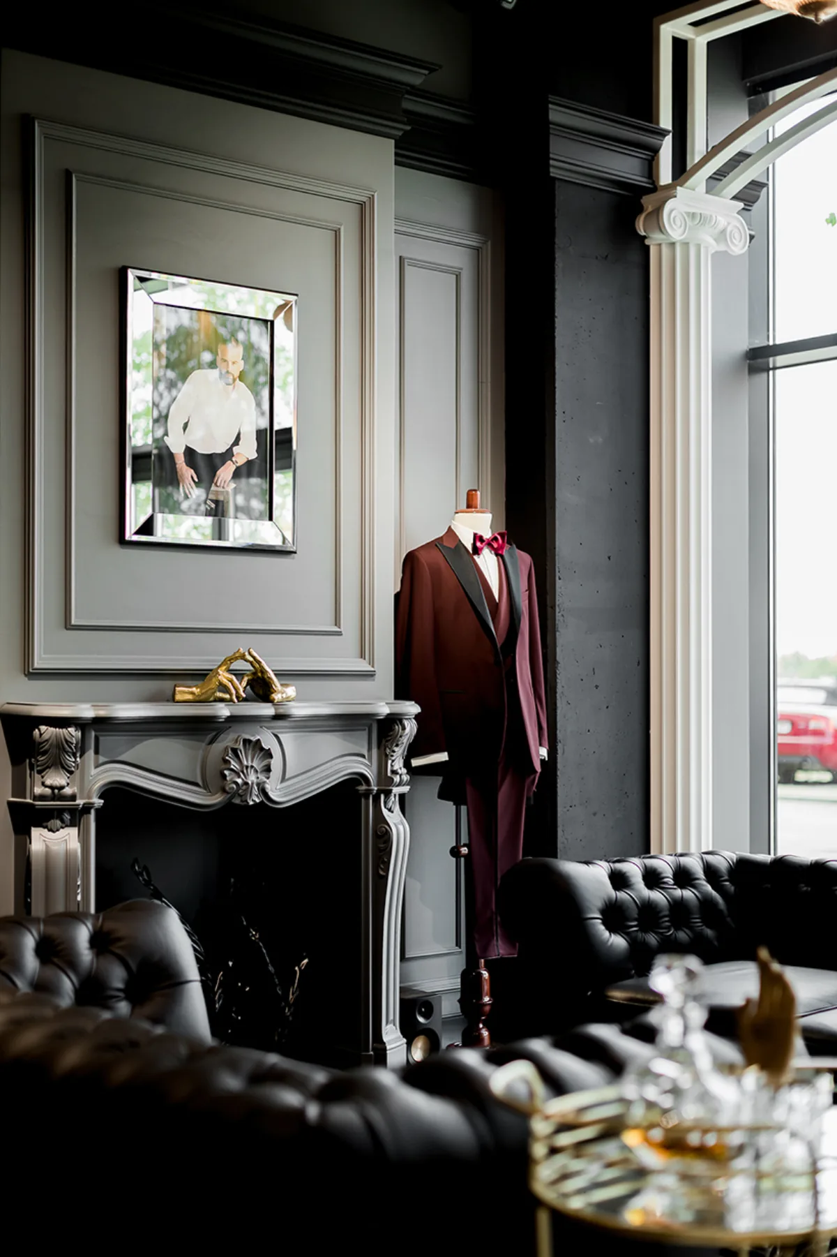 Dark lounge with a velvet sofa, fireplace and sculptural details